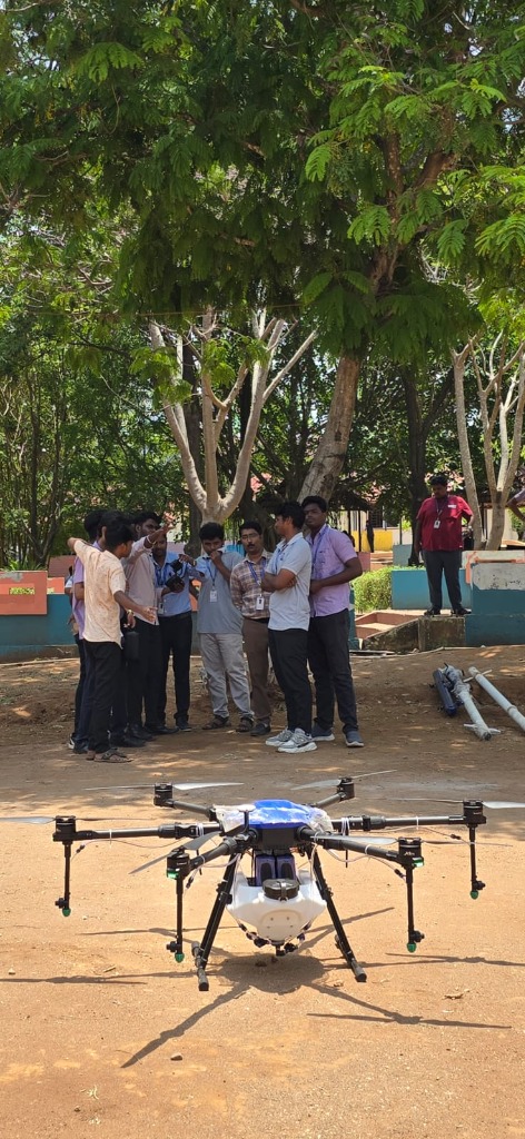 Group of farmers and trainees standing around a large hexacopter drone